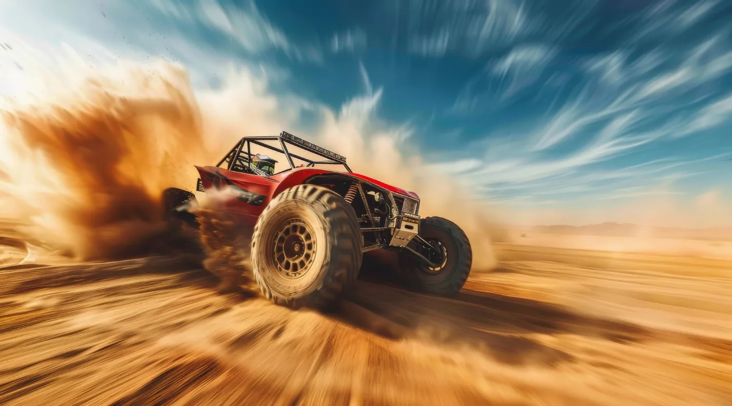 Vehículo todoterreno rojo en acción, levantando polvo en un desierto bajo un cielo despejado. Ideal para entusiastas de la aventura y el off-road.